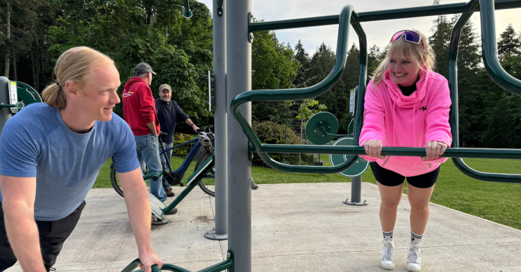 Two people using outdoor fitness equipment at the Mayne Island fitness park